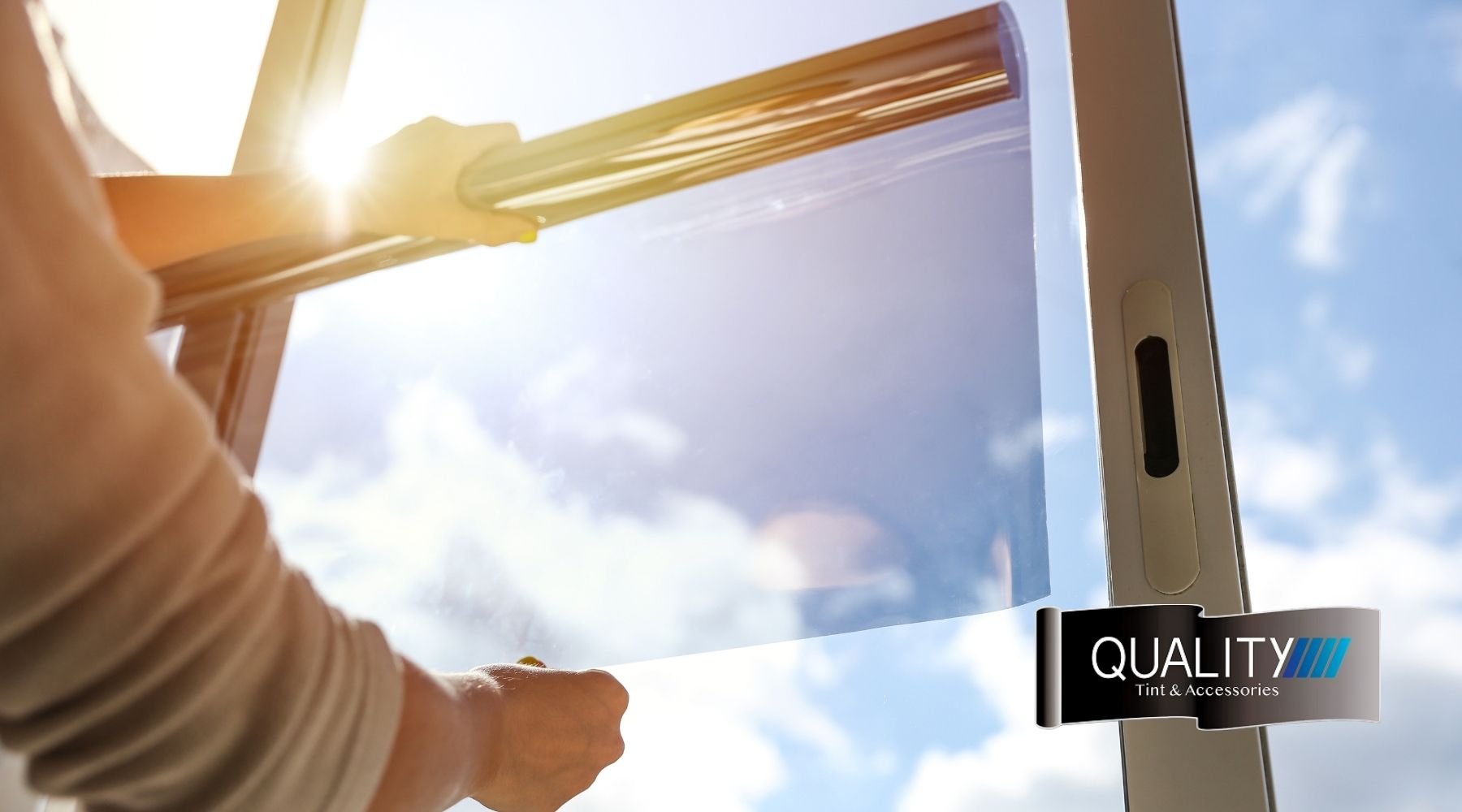 Black car with newly installed window tint inside a professional tinting shop.